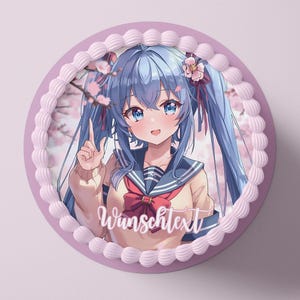 Può includere: Una torta rotonda con bordo rosa e rifiniture in glassa bianca. La torta presenta un'illustrazione in stile anime di una ragazza con i capelli blu e un'uniforme scolastica. Il testo "Wunschtext" è scritto sulla torta.
