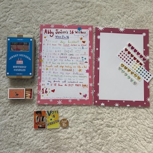 Peut inclure: Ensemble d'articles pour un Sweet Sixteen. Comprend une boîte bleue de bougies d'anniversaire, une boîte d'allumettes, une liste de souhaits manuscrite, des autocollants et un badge "Vote 4 Krista Sweet 16".
