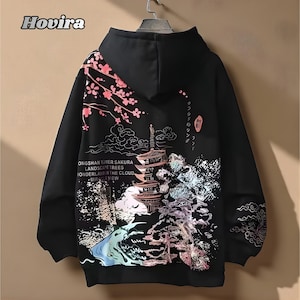 Pode incluir: Moletom preto com um design de inspiração japonesa. A parte de trás apresenta uma pagoda, flores de cerejeira e elementos de paisagem. O texto inclui "ONGSHAN TOWER SAKURA LANDSCAPE TREES WONDERLAND IN THE CLOUD MIRACLE VIEW".