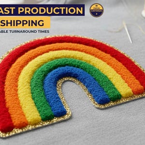 May include: A rainbow-shaped patch featuring vibrant red, orange, yellow, green, and blue arches. The patch has a gold glitter border. The text "FAST PRODUCTION & SHIPPING" is visible in the background. This patch is likely for clothing or accessories.