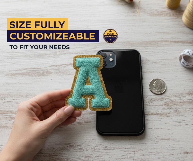 May include: A teal letter "A" patch with a gold border is held near a black smartphone. The patch is on a light-coloured surface. Text in the image reads "SIZE FULLY CUSTOMIZEABLE TO FIT YOUR NEEDS."