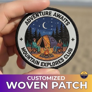Pode incluir: Remendo redondo tecido com o texto "ADVENTURE AWAITS MOUNTAIN EXPLORES CLUB". O remendo apresenta uma cena de acampamento com uma tenda, fogueira e duas pessoas. O fundo é um céu estrelado com uma lua crescente. A parte inferior do remendo diz "CUSTOMIZED WOVEN PATCH".