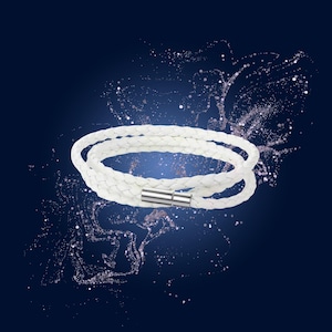 Può includere: Un braccialetto in pelle bianca intrecciata con chiusura magnetica argentata. Il braccialetto è avvolto due volte e posto su uno sfondo blu scuro con accenti scintillanti. Un accessorio elegante.