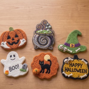 Könnte beinhalten: Sechs gefilzte Halloween-Dekorationen, darunter ein orangefarbener Kürbis mit Geistern, ein violetter Kessel mit grünen Blasen, ein grüner Hexenhut mit Totenköpfen, ein weißer Geist mit dem Text BOO, eine schwarze Katze und ein gelbes Schild mit HAPPY HALLOWEEN.