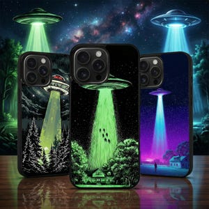 Op de afbeelding: Drie telefoonhoesjes met ontwerpen van buitenaardse ontvoeringen. Elk hoesje heeft een UFO met een lichtstraal die op een landschap schijnt. De achtergronden omvatten een sterrenhemel, bomen en een huis. De hoesjes zijn zwart.