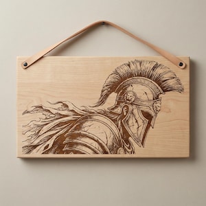 Könnte beinhalten: Wandbild aus Holz mit einer detaillierten Gravur eines spartanischen Kriegers im Profil. Das Kunstwerk ist in Braun- und Beigetönen gehalten und hat einen Lederriemen zum Aufhängen. Der Krieger trägt einen Helm mit hoher Feder auf hellem Holzgrund.