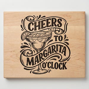 May include: A light-colored wooden cutting board with the words "Cheers to Margarita O'Clock" in a decorative black font. A margarita glass with a lime wedge is in the center of the design.