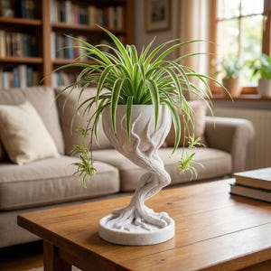 May include: A white, tree-trunk-shaped planter holding a green and white spider plant. The planter sits on a round base and has a twisted stem. The plant's long, slender leaves cascade downwards, creating a striking visual contrast.