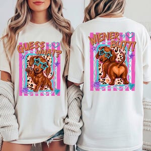 May include: Off-white t-shirts with a dachshund graphic. One shirt says "Guess What?" and the other says "Wiener Butt!" The dachshunds wear star-shaped glasses and are set against a pink and teal background with leopard print.