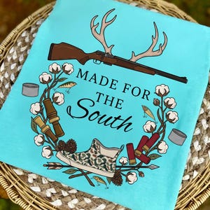 Puede incluir: Una taza de cerámica blanca con un asa negra y el texto "But First, Coffee" en un estilo manuscrito. La taza está sobre una superficie blanca. La taza mide aproximadamente 10 cm de alto.