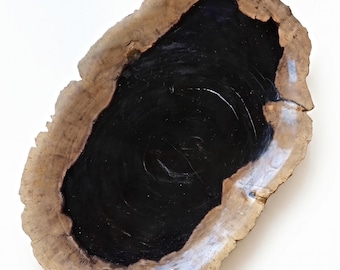 May include: An oval-shaped tray featuring a natural, rough-edged light brown wood border surrounding a smooth, glossy, deep black center. The piece has an organic, irregular perimeter with visible wood grain texture and a reflective finish.