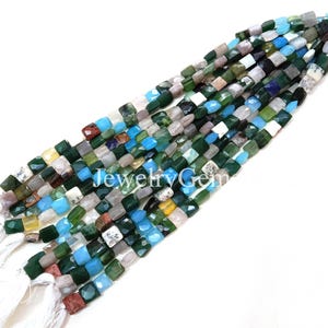 Puede incluir: Hebras de cuentas de piedras preciosas en tonos verdes, azules, blancos y marrones. Las cuentas cuadradas están facetadas, con piedras opacas y translúcidas. El texto "JewelryGem" es visible en la imagen.