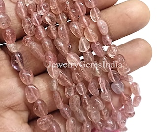 May include: Strands of pink gemstone beads with a polished, oval shape. The beads vary in color from light pink to a deeper rose hue. The beads are strung together, creating a necklace or bracelet.