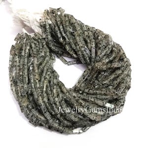 Könnte beinhalten: Ein Bündel transluzenter, rechteckiger Perlen mit schwarzen Sprenkeln. Die Perlen sind aufgefädelt und bilden eine dichte, strukturierte Masse. Das Bild enthält den Text "Jewelry Gems Inda".