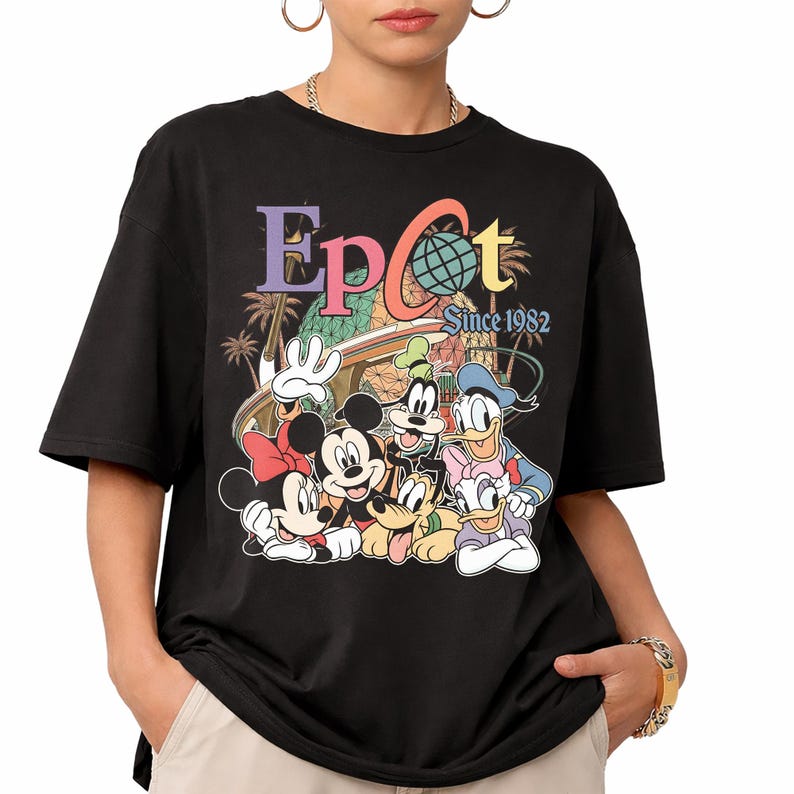 May include: Black t-shirt featuring a colorful graphic of Disney characters, including Mickey and Minnie Mouse, Goofy, Donald and Daisy Duck. The word "Epcot" is above the characters, with "Since 1982" below.