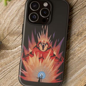 May include: Black phone case featuring a vibrant illustration of a red and orange creature with a blue orb and a silhouetted figure. The design is set against a backdrop of fiery bursts. The case is on a wooden surface.