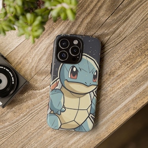 May include: A black smartphone case featuring a cartoon Squirtle character. The case has a dark blue background with white stars. Squirtle is blue with a beige belly and red eyes. The case is on a wooden surface.