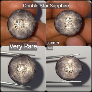 Pode incluir: Uma gema de safira estrela dupla oval de 33,00 quilates com um tom cinza-púrpura e inclusões internas visíveis. A pedra exibe um padrão de estrela de seis pontas na sua superfície cabochão, com o texto Double Star Sapphire, Very Rare, 33.00.Ct e Oval.