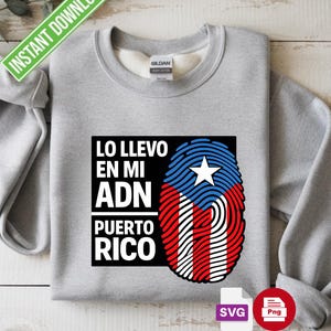 Puede incluir: Una sudadera gris con el texto "LO LLEVO EN MI ADN PUERTO RICO" en blanco, y un diseño de huella dactilar que incorpora la bandera de Puerto Rico. El diseño incluye una estrella blanca sobre fondo azul, con rayas rojas y blancas.