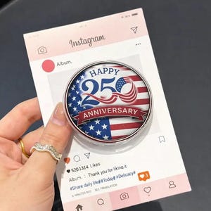 May include: A round, silver-rimmed button with an American flag design, celebrating a 250th anniversary. The button is held against a mock Instagram post. The text "HAPPY 250 ANNIVERSARY" is displayed on the button.