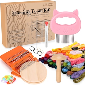 Könnte beinhalten: Ein Bastelset mit einem Karton mit der Aufschrift "Darning Loom Kit" und "50 Color Embroidery Threads". Das Set enthält einen rosa katzenförmigen Webstuhl, orangefarbene und hölzerne Werkzeuge, Nadeln und eine Vielzahl bunter Stickgarne.