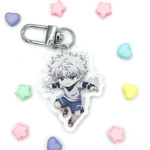 May include: A clear acrylic keychain featuring a cartoon character with spiky white hair, a light gray shirt, and dark blue shorts, surrounded by light blue lightning effects, attached to a silver metal lobster clasp and jump ring.
