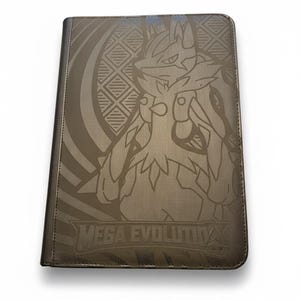May include: A rectangular trading card binder with a dark brown, textured cover featuring a line-art illustration of the character Lucario. The text MEGA EVOLUTION is printed in a stylized font at the bottom center of the front cover.