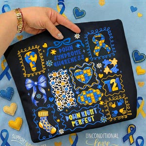 May include: Black t-shirt with Down Syndrome awareness graphics. The design includes puzzle pieces, ribbons, and the text "Down Syndrome Awareness" and "Down Right Perfect". The shirt features blue and yellow colors.