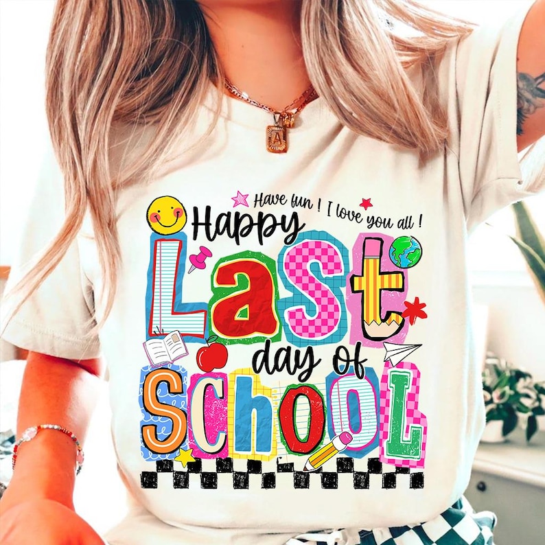 Pode incluir: Camiseta branca com um gr&aacute;fico colorido que diz "Happy Last Day of School". O design inclui um smiley, um l&aacute;pis, uma ma&ccedil;&atilde; e outros elementos escolares. O texto "Have fun! I love you all!" tamb&eacute;m est&aacute; inclu&iacute;do.