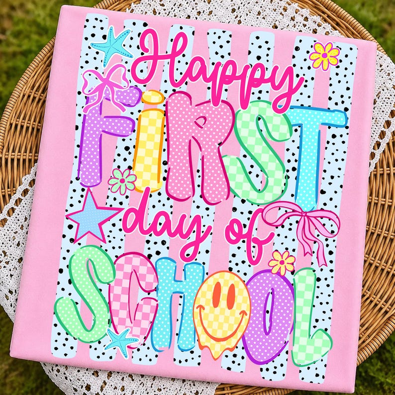 May include: A rectangular fabric panel featuring a pink background with vertical black polka-dot stripes. The text reads Happy FIRST day of SCHOOL in colorful, patterned letters. Decorative elements include a starfish, bow, and smiley face.