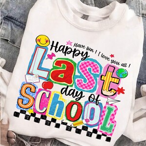Pode incluir: Camisola branca com um gr&aacute;fico colorido que diz "Happy Last Day of School". O design inclui um smiley, uma ma&ccedil;&atilde;, um l&aacute;pis e outros &iacute;cones relacionados com a escola. O texto "Have fun! I love you all!" tamb&eacute;m est&aacute; inclu&iacute;do.