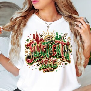 A woman with long, wavy blonde hair wearing a white t-shirt with a colorful graphic design that says "JUNE EENTH" and "1865".