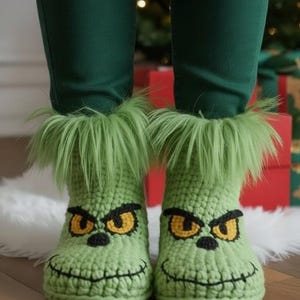 May include: A pair of light green crochet boots with a Grinch face design. The boots have black stitched details for the mouth and eyebrows, and yellow eyes. The top of the boots are trimmed with green faux fur.