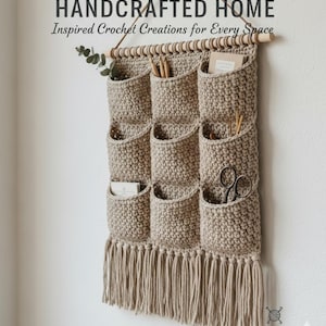 May include: Handmade crochet wall organizer with nine pockets, fringe, and a wooden dowel. The text reads "HANDCRAFTED HOME Inspired Crochet Creations for Every Space." The organizer is beige and hangs on a wall.