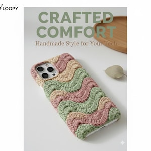 May include: A colorful, crocheted phone case with a wavy pattern in shades of pink, green, and beige. The case is designed to fit a smartphone and is labeled "Crafted Comfort: Handmade Style for Your Tech."