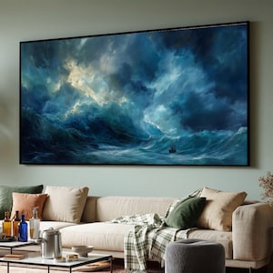 Peut inclure: Une grande œuvre d'art encadrée représentant une scène d'océan orageux avec un petit voilier. La peinture présente des vagues dramatiques dans des tons de bleu et de blanc, sous un ciel turbulent. L'œuvre est affichée au-dessus d'un canapé beige.