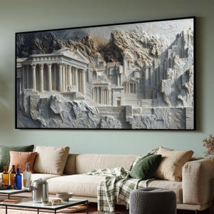 Puede incluir: Una gran obra de arte enmarcada que representa un relieve 3D detallado de una ciudad antigua con arquitectura clásica. La obra presenta estructuras blancas con columnas y escaleras, sobre un fondo de montañas texturizadas. El marco es negro.