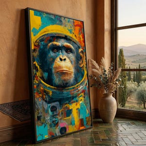 Peut inclure: Une impression d'art encadrée représentant un chimpanzé portant un casque d'astronaute. L'œuvre utilise une palette vibrante de bleus, de jaunes et d'oranges. Le visage du singe est détaillé, avec une expression sérieuse. L'impression est appuyée contre un mur près d'une fenêtre.