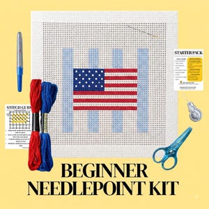 May include: A beginner needlepoint kit featuring a white canvas with a printed American flag design, red and blue embroidery thread, a needle, a needle threader, blue scissors, a blue marker, a stitch guide card, and a starter pack instruction card.
