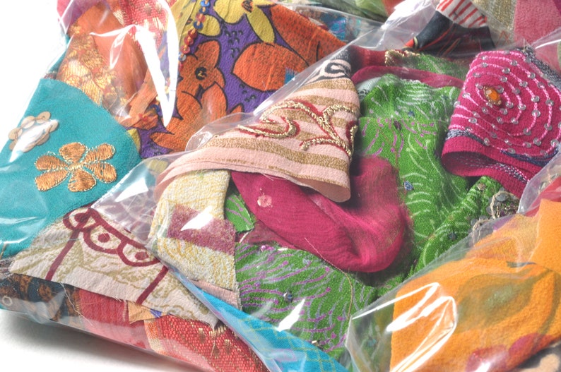 May include: A clear plastic bag filled with colorful fabric scraps. The scraps are made of various materials, including silk, cotton, and velvet. They are decorated with embroidery, sequins, and beads. The scraps are in a variety of colors, including red, green, blue, pink, and orange.