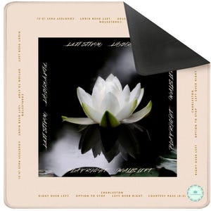 This is a mahjong mat. There is a peach border around the outside. Inside there is a black and white image of a lotus.