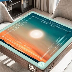 May include: A wooden game table with a glass top featuring a sunset design in shades of orange, blue, and white. The table has decorative side panels and is surrounded by two chairs. Text on the table reads "PLAY RIGHT" and "WALLS LEFT".