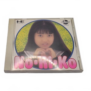 May include: A PC Engine CD-ROM game case titled No-Ri-Ko featuring a portrait of a person with long dark hair against a yellow floral background. The case includes the HE System logo and CD-ROM logo in the top corners with pink text at the bottom.
