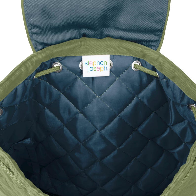 May include: Green drawstring backpack with a quilted blue lining. The inside of the bag has a label that reads "stephen joseph".