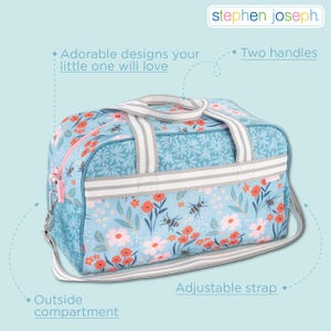 May include: A light blue duffel bag featuring a floral and bee pattern with red and white flowers. The bag includes two striped handles, an adjustable shoulder strap, and an outside compartment. The Stephen Joseph logo is visible at the top.