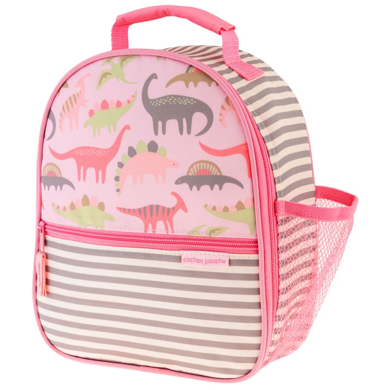May include: Pink lunch bag with a dinosaur print and a striped design. The bag has a zipper closure and a mesh side pocket. The bag has the text "stephen joseph" on the front.