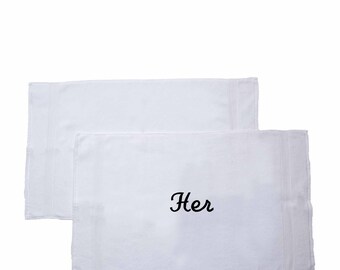 May include: Two rectangular white hand towels with a textured border. One towel is plain, while the other features the word "Her" embroidered in black script lettering in the center. The brand name "Lavington Designs" is printed in the bottom left corner.