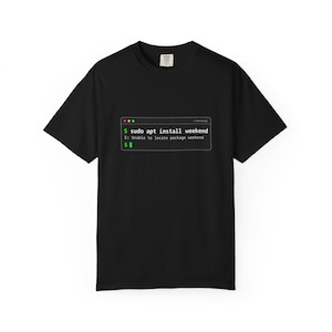 Może przedstawiać: Czarny t-shirt z krótkim rękawem z białą grafiką przedstawiającą okno terminala komputerowego. Tekst wewnątrz brzmi: $ sudo apt install weekend, E: Unable to locate package weekend oraz $. Projekt naśladuje interfejs wiersza poleceń.