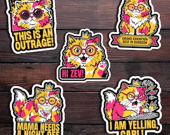 May include: A collection of five colorful cat stickers with various phrases. The cats are yellow and pink, wearing glasses and crowns. Phrases include "THIS IS AN OUTRAGE!", "HI ZEV!", and "I AM YELLING, CARL!"