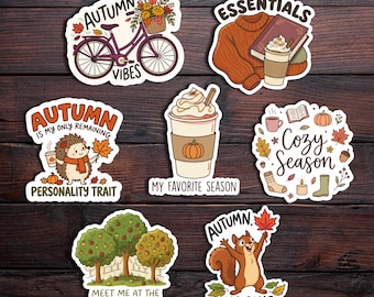 May include: A collection of seven die-cut stickers featuring autumn themes including a bicycle with flowers, a sweater with a book and coffee, a hedgehog, a pumpkin latte, cozy icons, apple trees, and a squirrel holding a maple leaf.